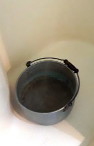 Metal bucket catching shower water